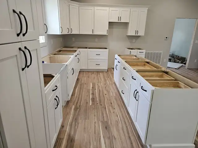 White shaker cabinets installed around a kitchen and island, ready for countertops